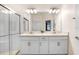 Elegant bathroom featuring double sinks, quartz countertops, modern fixtures, and a glass-enclosed shower at 17214 Star Banks St, Wimauma, FL 33598