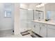 Bright bathroom featuring a glass-enclosed shower, white cabinets, and modern tile flooring at 17214 Star Banks St, Wimauma, FL 33598
