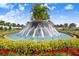 Beautiful community fountain surrounded by lush landscaping and colorful flowers at 17214 Star Banks St, Wimauma, FL 33598