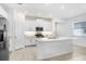 Bright, all-white kitchen featuring a large island, stainless steel appliances, and modern finishes at 17214 Star Banks St, Wimauma, FL 33598