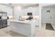 Bright, all-white kitchen featuring a large island, stainless steel appliances, and modern finishes at 17214 Star Banks St, Wimauma, FL 33598