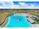 A turquoise lagoon with inflatables offers a resort-style experience amidst a residential community, perfect for recreation and relaxation at 17214 Star Banks St, Wimauma, FL 33598