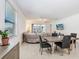Bright, open-concept living room with dining area, large sectional sofa, and tiled flooring at 17214 Star Banks St, Wimauma, FL 33598