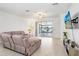Bright living room with a large sectional, sliding glass doors to the patio, and a wall-mounted TV at 17214 Star Banks St, Wimauma, FL 33598