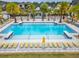 Community pool surrounded by lounge chairs and beautiful landscaping at 19611 Cypress Bridge Dr, Odessa, FL 33556