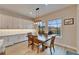 Dining area with a dark wood table, windows to a screened in pool, and white cabinets at 19611 Cypress Bridge Dr, Odessa, FL 33556