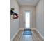 Inviting foyer with decorative rug, coat rack, and light wood-look flooring, providing a warm welcome at 19611 Cypress Bridge Dr, Odessa, FL 33556