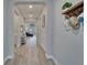 Inviting hallway with wood floors leading to a living area; features a coat rack and wall decor at 19611 Cypress Bridge Dr, Odessa, FL 33556