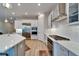 Bright kitchen with stainless steel appliances, light wood floors, white cabinets, and quartz countertops at 19611 Cypress Bridge Dr, Odessa, FL 33556