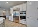 Stainless steel refrigerator, microwave, and oven built into white cabinets in this home's kitchen at 19611 Cypress Bridge Dr, Odessa, FL 33556
