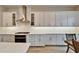 Bright kitchen with white cabinets, stainless steel hood, quartz countertops, and wood floors at 19611 Cypress Bridge Dr, Odessa, FL 33556