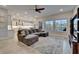 Open-concept living room showcasing a sectional sofa, a TV, and backyard pool views through large windows at 19611 Cypress Bridge Dr, Odessa, FL 33556