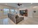 Well-lit living room with a sectional sofa, a large television, and an exterior view with large windows at 19611 Cypress Bridge Dr, Odessa, FL 33556