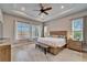 Spacious main bedroom featuring a tray ceiling, ceiling fan, and large windows at 19611 Cypress Bridge Dr, Odessa, FL 33556