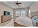 Light-filled main bedroom featuring a neutral color palette, TV, and sliding glass door at 19611 Cypress Bridge Dr, Odessa, FL 33556