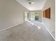 Spacious bedroom with carpet flooring, neutral colors, a ceiling fan, and sliding door access to a private balcony at 2011 Arbor Dr, Clearwater, FL 33760
