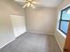 This is a comfortable bedroom with neutral colors, a ceiling fan, carpeted floors and a window for natural light at 2011 Arbor Dr, Clearwater, FL 33760