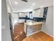 Modern kitchen with white cabinetry, blue backsplash, updated appliances, and a breakfast bar at 2011 Arbor Dr, Clearwater, FL 33760