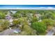 Panoramic aerial view of the neighborhood, showcasing the house nestled among lush trees and a lake at 22119 Weeks Blvd, Land O Lakes, FL 34639