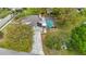 Aerial view showcasing the house with pool, screened enclosure, solar panels, and extended driveway at 22119 Weeks Blvd, Land O Lakes, FL 34639