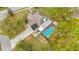 Aerial view showcasing the house with pool, screened enclosure, solar panels, and extended driveway at 22119 Weeks Blvd, Land O Lakes, FL 34639