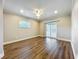 Bedroom features wood floors, ceiling fan, a window, and a sliding glass door with backyard access at 22119 Weeks Blvd, Land O Lakes, FL 34639