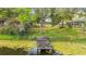 Wooden dock extending into the lake, surrounded by trees and lush greenery at 22119 Weeks Blvd, Land O Lakes, FL 34639