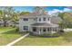 Charming two-story home featuring a cozy, covered front porch and lush landscaping at 22119 Weeks Blvd, Land O Lakes, FL 34639