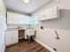 Well-lit laundry room featuring ample cabinet space and utility sink at 22119 Weeks Blvd, Land O Lakes, FL 34639
