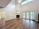 Inviting living room features a vaulted ceiling, fireplace, and sliding glass doors to the backyard and pool at 22119 Weeks Blvd, Land O Lakes, FL 34639