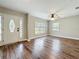 Inviting living room featuring wood floors, a ceiling fan, and large windows that offer an abundance of natural light at 22119 Weeks Blvd, Land O Lakes, FL 34639