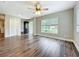 Open living room with wood floors, ceiling fan, and a large window at 22119 Weeks Blvd, Land O Lakes, FL 34639