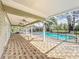 Large screened patio with brick floors, ceiling fans, and outdoor living space at 22119 Weeks Blvd, Land O Lakes, FL 34639