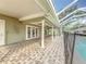 Covered patio with brick floors, ceiling fans, and access to pool area at 22119 Weeks Blvd, Land O Lakes, FL 34639
