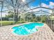 Screened pool area with brick patio and lush landscaping at 22119 Weeks Blvd, Land O Lakes, FL 34639