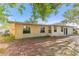 Spacious backyard featuring a brick patio, lush trees, and the home's exterior at 230 Davison Ne Ave, St Petersburg, FL 33703