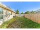 View of the home's overgrown backyard, featuring a brick pathway and wooden fence at 230 Davison Ne Ave, St Petersburg, FL 33703