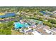 Beautiful aerial view of a pool, tennis courts, parking, lush green landscaping and residential homes at 2618 Newcomb Ct # 12, Sun City Center, FL 33573