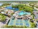 Overhead shot of the community pool, tennis courts, clubhouse, and lush greenery in the community at 2618 Newcomb Ct # 12, Sun City Center, FL 33573