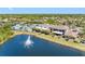 Beautiful aerial view of clubhouse, pool, lush green landscaping, residential homes and water fountain at 2618 Newcomb Ct # 12, Sun City Center, FL 33573