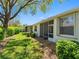 The backyard features a lush lawn, mature landscaping, and a partially screened exterior of the home at 2618 Newcomb Ct # 12, Sun City Center, FL 33573