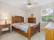 Bedroom with wood furniture, tile flooring, and a sunlit window overlooking the greenery outside at 2618 Newcomb Ct # 12, Sun City Center, FL 33573
