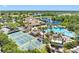 Aerial shot showcases a community pool, clubhouse, tennis courts, and a lakeside view at 2618 Newcomb Ct # 12, Sun City Center, FL 33573