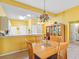 Bright dining area features a chandelier, wood table, and access to the kitchen and living spaces at 2618 Newcomb Ct # 12, Sun City Center, FL 33573