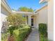 Charming home entrance with manicured shrubbery, a walkway, and a well-lit doorway at 2618 Newcomb Ct # 12, Sun City Center, FL 33573