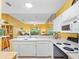 Open kitchen with an island and white appliances with view into the living area at 2618 Newcomb Ct # 12, Sun City Center, FL 33573