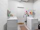 Laundry room equipped with a washer, dryer, and storage shelves at 2618 Newcomb Ct # 12, Sun City Center, FL 33573