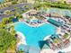 Aerial view of a large, resort-style pool with palm trees and plenty of seating for relaxation at 2618 Newcomb Ct # 12, Sun City Center, FL 33573