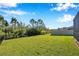 Spacious and well-maintained backyard with fencing and mature trees, offering privacy at 2934 Living Coral Dr, Odessa, FL 33556