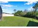 Lush green backyard with a combination of white and black metal fencing and mature trees at 2934 Living Coral Dr, Odessa, FL 33556